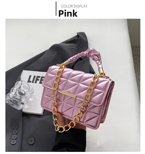 Close-up of pink quilted handbag with gold chain strap and elegant pleated handle detail