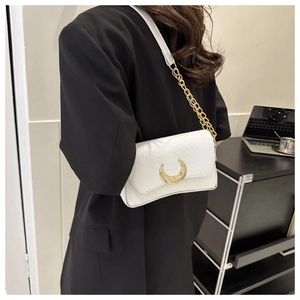 White textured shoulder bag featuring a gold crescent magnetic buckle and chain strap