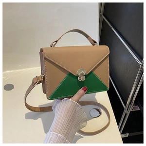 Detail of contrast color beige and green handbag featuring white stitching and metal twist lock