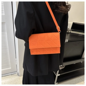 Détail d'un sac bandoulière orange vif en feutre matelassé avec sangle réglable