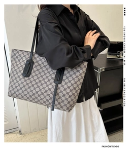 Detail of vintage patterned tote bag with black leather straps for daily commute