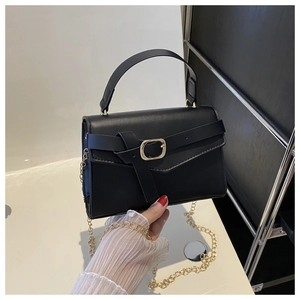 Close-up of black PU leather handbag with gold chain strap and stylish metal buckle detail