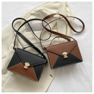 Detail of color-block envelope bags with gold semi-circle locks on neutral fabric