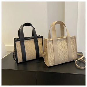 Dettaglio della borsa tote in paglia intrecciata con finiture in ecopelle e tracolla