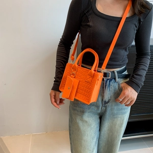 Orange faux leather crossbody bag with crocodile pattern and mini coin purse charm