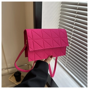 Détail du sac à bandoulière en feutre rose avec motif géométrique de triangles matelassés