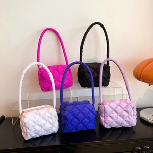 Minimalist quilted nylon shoulder bags in five vibrant colors displayed on a sleek stand