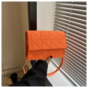 Gros plan sur un sac bandoulière orange en feutre avec des surpiqûres triangulaires
