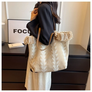 Detail of bohemian knit tote bag with tassel fringe and geometric triangle patterns