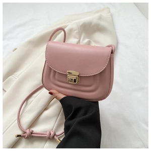 Close-up of pink crossbody bag featuring gold metal lock and curved stitch detail