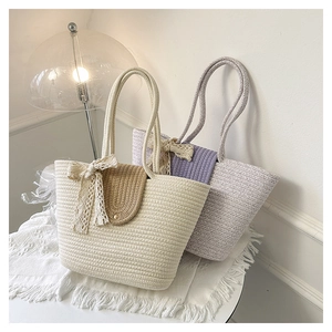 Close-up of handmade woven tote bags with lace bows and metallic round buckles