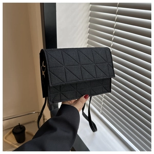Détail d'un sac à bandoulière en feutre noir matelassé avec coutures triangulaires