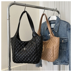 Detail of quilted rhombus texture and metal buckle on black and camel tote bags