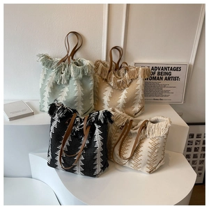 Collection of hand-woven tote bags in green, khaki, black and beige with fringe