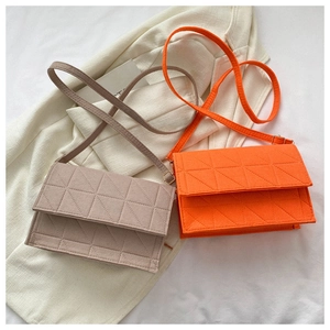 Gros plan détaillé des sacs en feutre matelassé rose et orange avec motifs géométriques