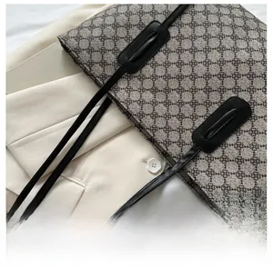 Detailed top view of vintage tote bag with geometric clover pattern and long leather strap