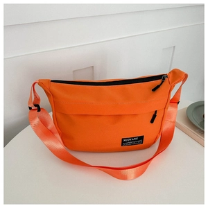 Detail of bright orange nylon crossbody bag with dual black zippers and brand logo tag