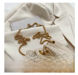 Détail montrant la texture tissée et la chaîne dorée du sac seau minimaliste