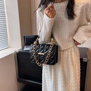 Chic quilted black patent leather handbag with a bold gold chain and turn-lock closure