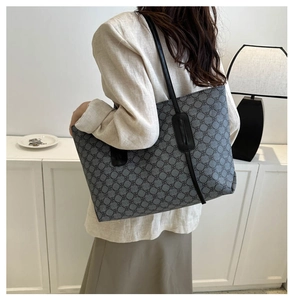 Detailed side view of grey floral pattern tote bag worn by a model in minimalist interior