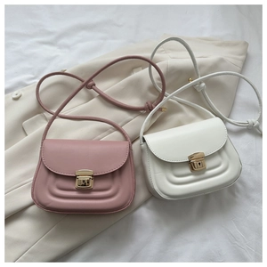 Detail view of pink and white mini shoulder bags with U-shaped quilting and gold locks