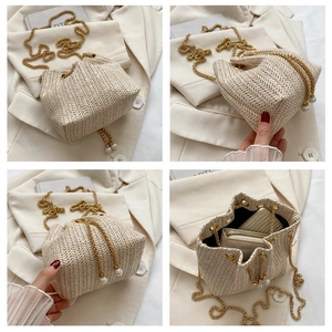 Detail view showing beige woven bucket bag with pearl drawstring and golden chain strap