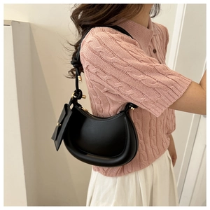 Detail of black leather hobo bag with gold zipper and matching coin purse charm