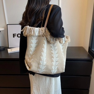 Bohemian woven tote bag with fringe detail and geometric patterns for summer fashion
