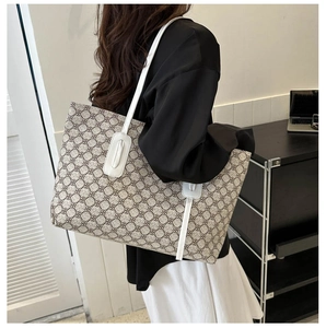 Side view of large tote bag with vintage pattern and white straps on a model