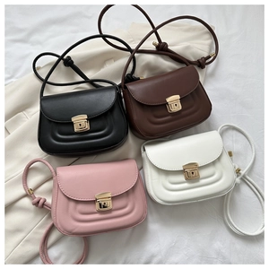 Flat lay of vintage saddle bags in black, brown, cream, and pink with U-shaped stitching