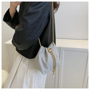 Détail du sac seau à paillettes argentées avec chaîne dorée et glands coulissants en perles
