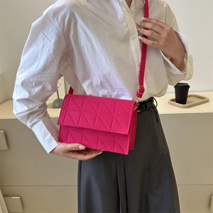 Sac bandoulière en feutre magenta avec surpiqûres triangulaires sur un mannequin