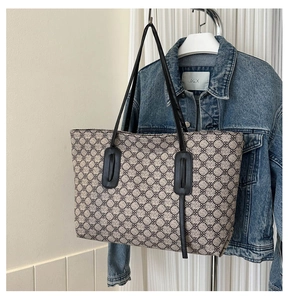 Detail of jacquard canvas tote bag with retro clover patterns and leather straps