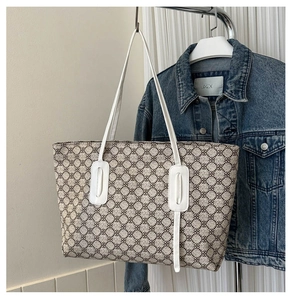 Detail of vintage tote bag with geometric floral pattern and white leather handles