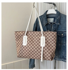 Detail view of a large vintage print tote bag with white leather straps and canvas texture
