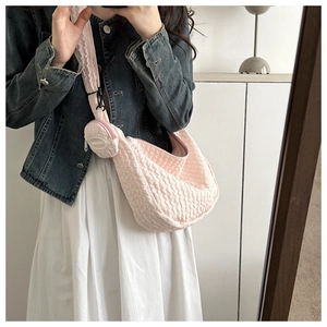 Detail of light pink pleated shoulder bag featuring a matching round zipper coin purse attachment