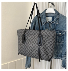 Detail of grey geometric jacquard tote bag with black leather straps and retro texture