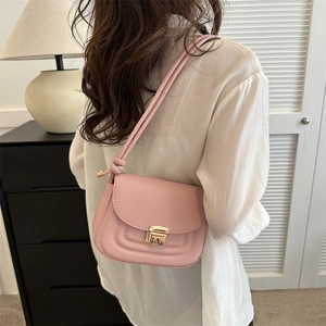 Pink minimalist faux leather crossbody bag with gold snap closure on a model