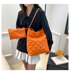 Détail du sac seau matelassé orange avec bandoulière chaîne et pochette assortie