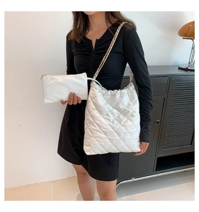 Détail du sac cabas matelassé blanc avec pochette zippée assortie et chaîne dorée