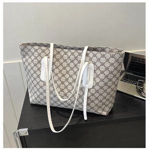 Close-up of large canvas tote bag with geometric pattern and white leather handles