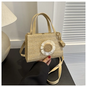 Detail of woven straw bag featuring a large white daisy flower and PU shoulder strap