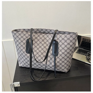Detail of grey-black geometric clover pattern on large tote bag with laptop