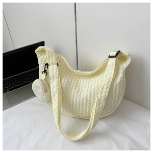 Detail of creamy white bubble quilted shoulder bag with matching round coin purse charm