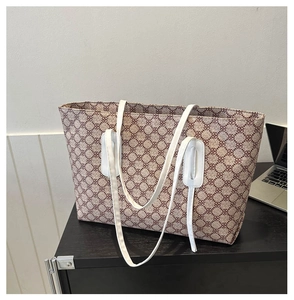 Detailed view of spacious tote bag with geometric print next to a laptop for scale