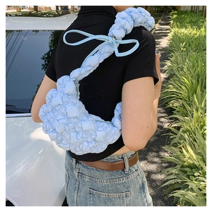 Detail of light blue pleated puffy shoulder bag featuring a cute bow strap decoration