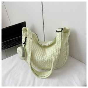 Detail of light yellow crescent shoulder bag with pleated texture and coin purse charm