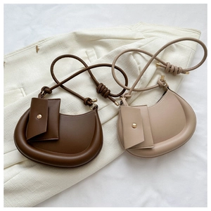 Detail of half-moon crossbody bags in brown and beige with knotted straps and mini pouch