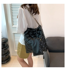 Détail du sac cabas matelassé noir avec bandoulière chaîne et pochette zippée assortie
