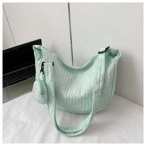 Detail of mint green pleated crescent bag with fashion tag and mini round coin purse
